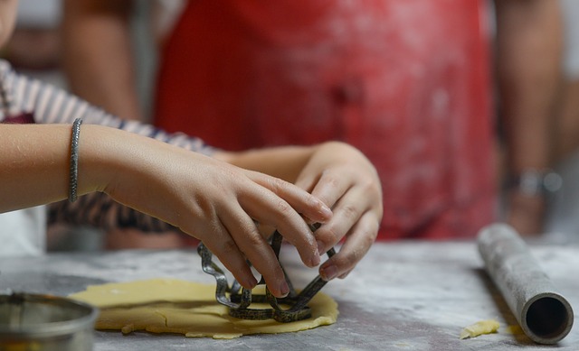 hands pressing cookie cutter into dough